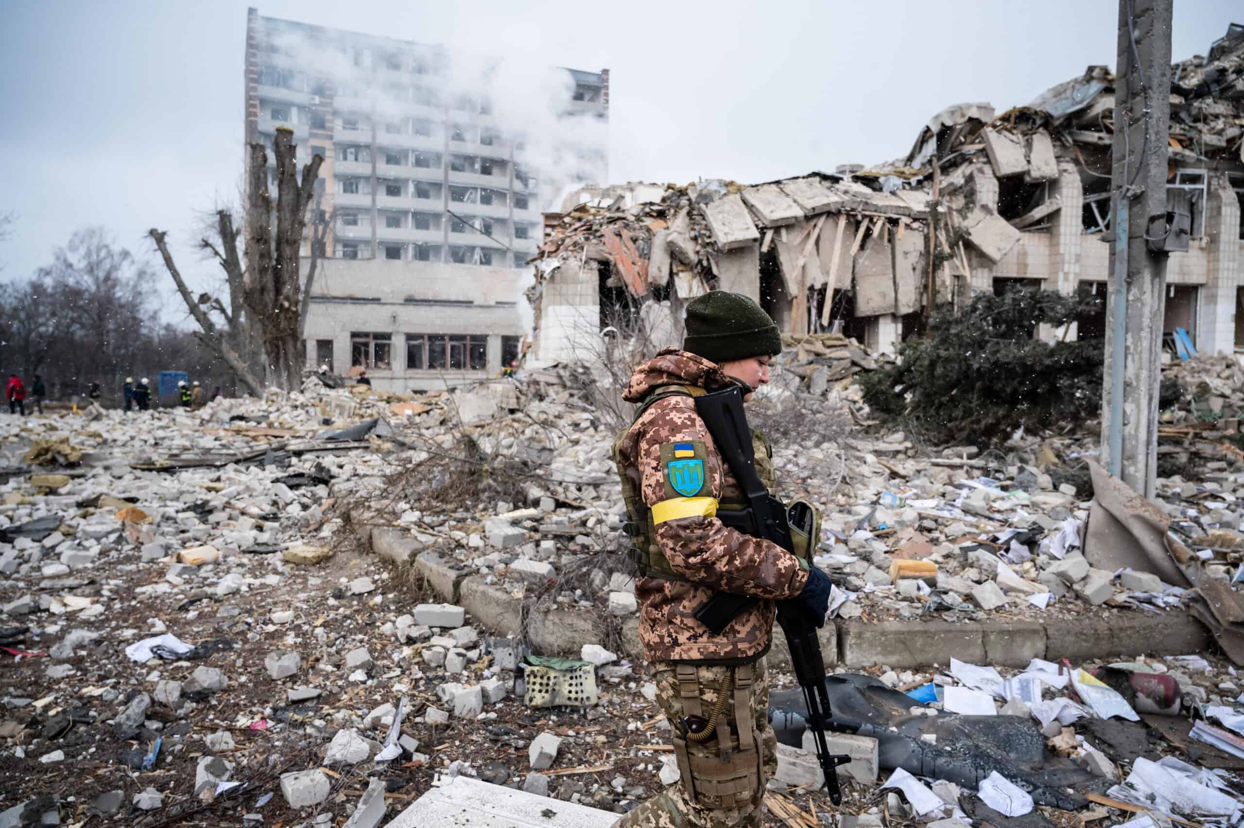 Ukrainian soldier stands in rubble of a bombed school