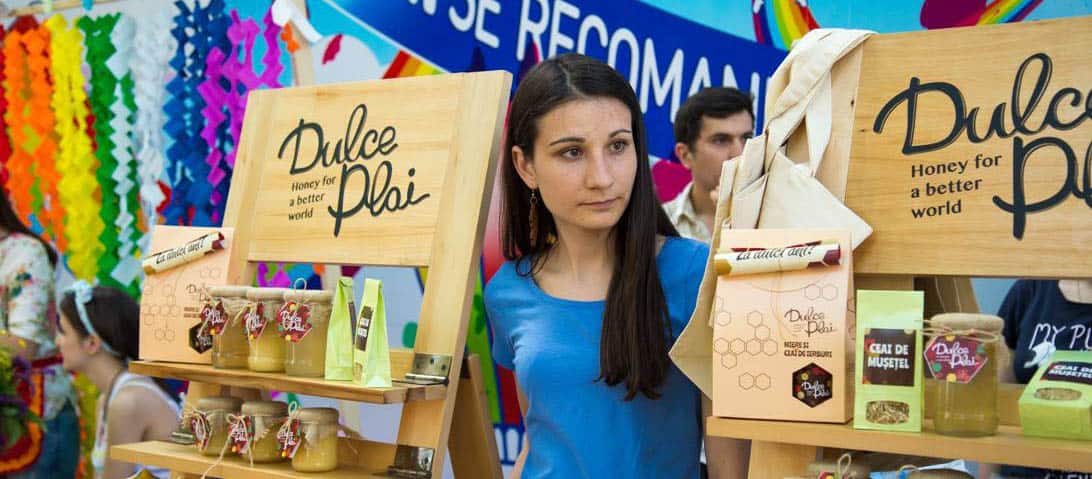 Young woman with long dark hair standing next to honey products