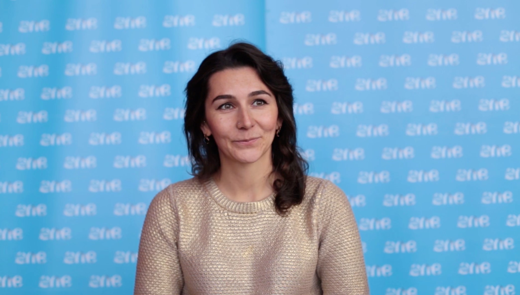 Woman in front of blue panel