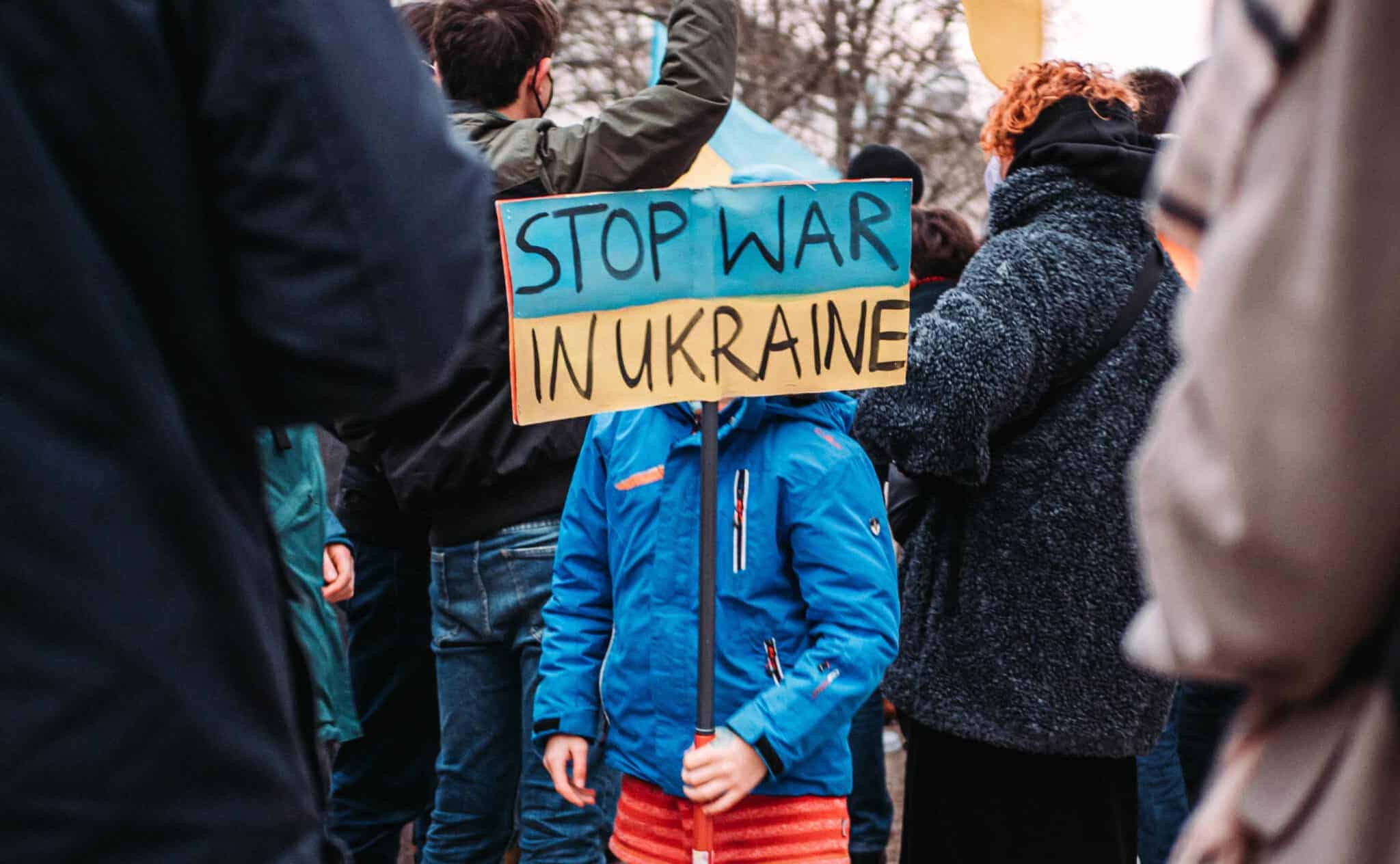 A child holding up a sign 'Stop war in Ukraine'