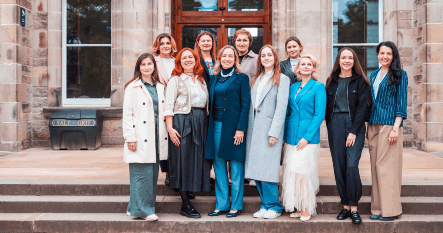 12 women / John Smith Fellows on steps in front of the Edinburgh Business School